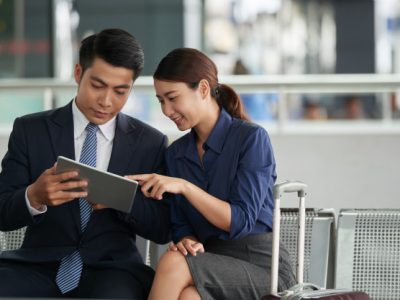 asian couple using tablet airport